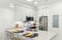 Modern kitchen with sleek countertops, stainless steel appliances, and elegant cabinetry, featuring a cozy breakfast bar set for two.