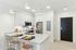 Modern kitchen with sleek white cabinets, stainless steel appliances, and a stylish breakfast bar with chic seating.