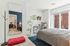 Bright and stylish bedroom with natural light, sleek desk, modern decor, and cozy ambiance.