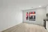 Bright, modern apartment interior with large windows, sleek kitchen appliances, and elegant wooden flooring. Perfect for stylish city living.