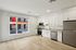 Bright modern kitchen with sleek white cabinetry, stainless steel appliances, and expansive window views.