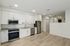 Modern kitchen with sleek white cabinetry, stainless steel appliances, and elegant wood flooring, perfect for stylish living.