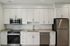 Modern kitchen featuring sleek stainless steel appliances, elegant white cabinetry, and polished countertops.
