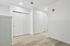Bright and modern hallway with elegant wooden flooring and sleek white doors, creating a welcoming ambiance.
