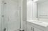 Bright and modern bathroom featuring a sleek glass-enclosed shower and elegant vanity.