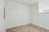 Modern minimalist room with crisp white walls and sleek wooden flooring, perfect for creative interior design possibilities.