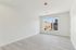 Bright and spacious empty room with modern light-colored flooring and a large window offering cityscape views, perfect for customization.