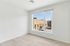 Bright, modern room with large window offering a stunning urban view and sleek wood flooring.