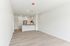 Modern, open-concept apartment featuring a sleek kitchen with stainless steel appliances, ample natural light, and elegant wood flooring.