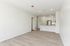 Bright and modern living space featuring sleek wood flooring and a contemporary open kitchen with elegant cabinetry and stainless steel appliances.