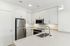 Modern kitchen with sleek stainless steel appliances, pristine white cabinetry, and a quartz countertop with built-in sink.