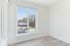 Bright and airy apartment room showcasing stylish flooring and a large window with a scenic view, perfect for natural lighting enthusiasts.