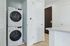 Modern laundry space with sleek stacked washer and dryer, set in a bright and inviting apartment interior.