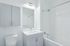 Bright and modern bathroom with elegant subway tile walls, a sleek vanity, and a spacious mirror creating a clean and inviting atmosphere.