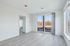 Bright and airy apartment room featuring elegant light wood flooring and large windows with scenic views.