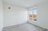 Bright, spacious room with modern flooring and a large window offering scenic views.