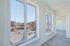 Bright and modern apartment interior with large windows offering stunning cityscape views and abundant natural light.