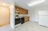 Bright and welcoming kitchen area with ample wooden cabinetry, sleek black appliances, and pristine white refrigerator.