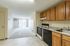 Sunny apartment kitchen with modern appliances, sleek countertops, and a view into the bright living space, perfect for comfortable living.