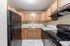 Modern kitchen featuring elegant wooden cabinetry, sleek black appliances, and a spacious countertop for meal preparation.