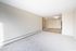 Inviting modern apartment interior with fresh carpet and bright natural light, leading to a tiled entryway with sleek contemporary lighting.