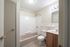 Elegant and well-lit bathroom featuring a sleek bathtub, modern vanity, and stylish lighting fixtures.