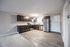 Modern kitchen with sleek dark cabinets, stainless steel appliances, and ample natural light.