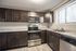 Modern kitchen with sleek dark wood cabinets, stainless steel appliances, and granite countertops.
