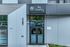Chic modern entrance of 'the charley' featuring sleek glass doors and contemporary exterior design.