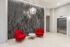 Elegant lobby with modern textured wall, sleek elevator, and vibrant red seating.