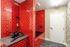 Vibrant pet grooming room with striking red tiles, modern equipment, and sleek design.