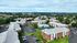 Stunning aerial view featuring red brick buildings, a swimming pool, and a tennis court surrounded by green lawns and trees at our pet-friendly apartments in Worcester, MA. | Princeton Place Apartments | Pet Friendly Apartments in Worcester