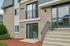 Inviting apartment exterior with modern brick design, welcoming entryway, and lush landscaping.