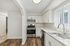 Bright kitchen with modern stainless steel appliances, elegant white cabinetry, and sleek countertops, offering a stylish and functional cooking space.
