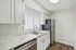 Modern kitchen with elegant white cabinetry, sleek stainless steel appliances, and stylish marble countertops.