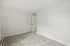 Spacious, sunlit room with plush carpeting, fresh white walls, and modern door detail.