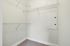Princeton Westford Apartments | Spacious walk-in closet in an apartment in Westford, MA, featuring beige carpet, white walls, wire shelving on two sides, and an electrical panel on the right. The space is well-lit and clean. | Apartments with Walk-in closets in westford
