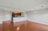 Grandview Apartments | Spacious, unfurnished open-plan living area at Grandview Apartments in Lowell MA, with hardwood floors, light gray walls, and a modern kitchen featuring dark cabinets, stainless steel appliances, and a breakfast bar. Multiple doors and ceiling lights are visible. | Wheelchair Accessible Apartments in Lowell