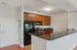 Grandview Apartments | Modern kitchen with wood cabinets, black appliances, granite countertop, and a breakfast bar. This inviting space at Grandview Apartments in Lowell MA features a stove, microwave, refrigerator, and stainless steel sink with natural light. | Apartments with Balcony in Lowell