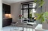 Modern dining nook at The Charley Apartments in Allston MA features a round white table, three black stools, a vase of flowers, and books. A large window overlooks the patio while dark cabinets and soft lighting create a cozy atmosphere. | The Charley | Apartment in Allston, MA