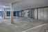 A clean, empty indoor parking garage at The James Apartments in Haverhill MA, featuring concrete floors and walls, numbered parking spaces, and two bicycles mounted on a wall rack.The James | Apartment in Haverhill, MA
