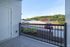 Enjoy the view from a covered patio at The James Apartments in Haverhill, MA, overlooking a parking lot with a red car, and landscaped grounds beneath the blue sky.  | The James | Apartment in, Haverhill MA