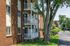 Charming brick apartment building with inviting balconies nestled among lush greenery.