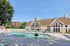 Pheasant Run Apartments | Enjoy the bright, sunny days at Pheasant Run Apartments in Nashua NH, featuring an outdoor swimming pool area with turquoise lounge chairs under a white pergola, surrounded by a white fence and lush trees beneath clear blue skies. | Apartments with Balcony in Nashua