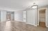 Princeton Properties | Bright, empty apartment room at Brookstone Manor Apartments in Milford, New Hampshire—features light wood flooring, white walls, a sliding glass door to a balcony, overhead light fixture, double-door closet, and view into a bathroom with tub. | Milford Apartments with Virtual Tours