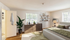 Inviting bedroom with large windows, elegant decor, and lush indoor plant, enhancing the cozy atmosphere of this stylish apartment.| The Royal Crest | Apartment in North Andover, MA