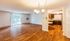 Inviting apartment featuring a spacious open living area with warm wood flooring, elegant chandelier lighting, and sliding glass doors leading to a serene outdoor view.| The Royal Crest | Apartment in North Andover, MA