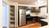 Modern kitchen with stainless steel appliances, ample wood cabinetry, and an open pantry with wooden flooring.Your spacious kitchen offers generous square footage with room for multiple people and all your cooking essentials.  | The Royal Crest | Apartment in,North Andover MA