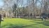 Vibrant fenced outdoor area with lush green grass and surrounding tall trees, ideal for relaxation and enjoyment.| The Royal Crest | Apartment in North Andover, MA
