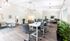 Bright and modern workspace featuring sleek grey chairs and tables, large windows, and vibrant greenery for a fresh atmosphere.| The Royal Crest | Apartment in North Andover, MA